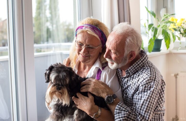 Jaki pies dla seniora? Na zdjęciu szczęśliwa para seniorów ze swoim psem.